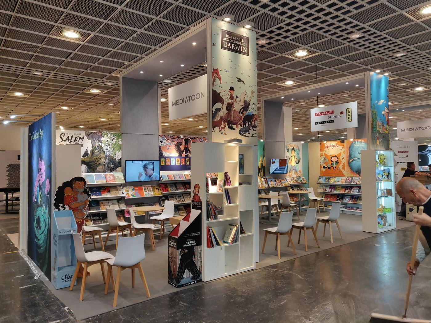 Stand de salon du livre avec habillage mural Méliès et espace lecture éditeurs Mediatoon, Dargaud et Dupuis